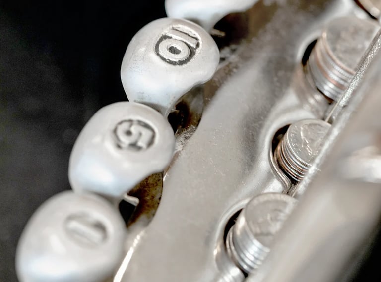 Close-up of white valve caps with numbers on engine or industrial machinery