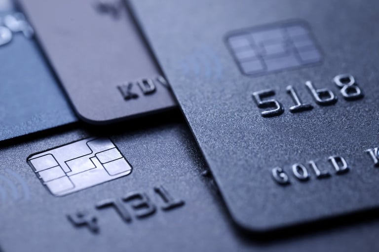 Close-up of three black credit cards showing embossed numbers and chip details